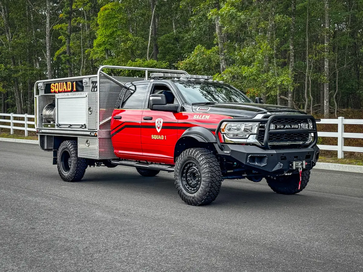 Front-left exterior view showing cab, side compartments, and front guard bumper.